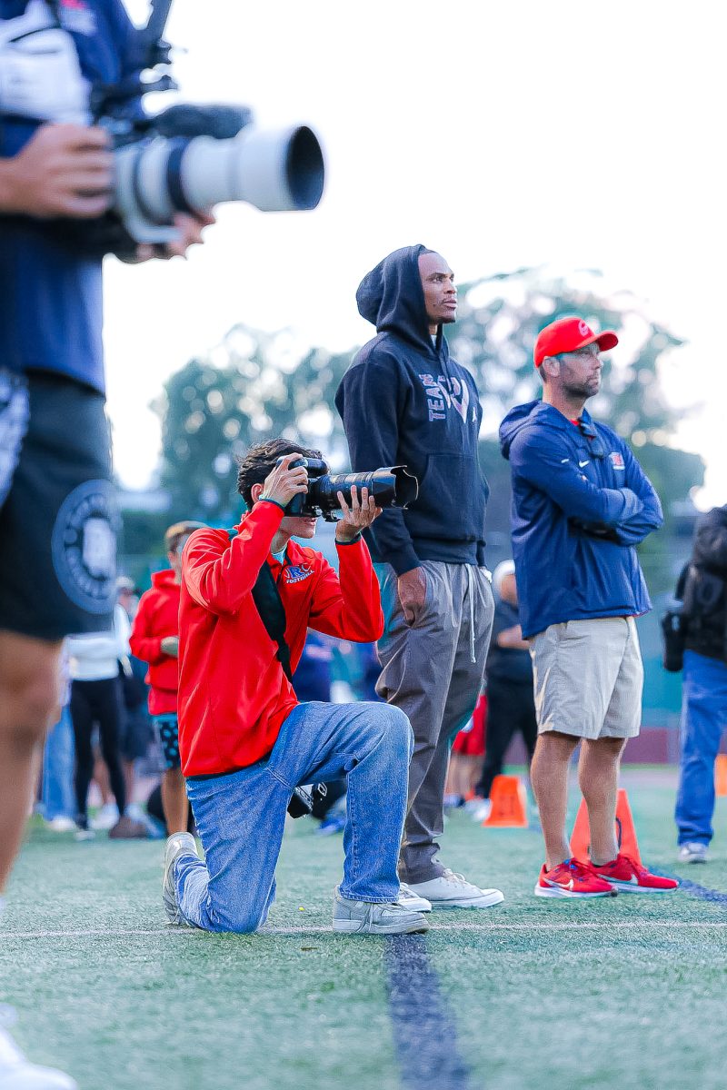 Phung photographs football game with Russel Westbrook at his side.
