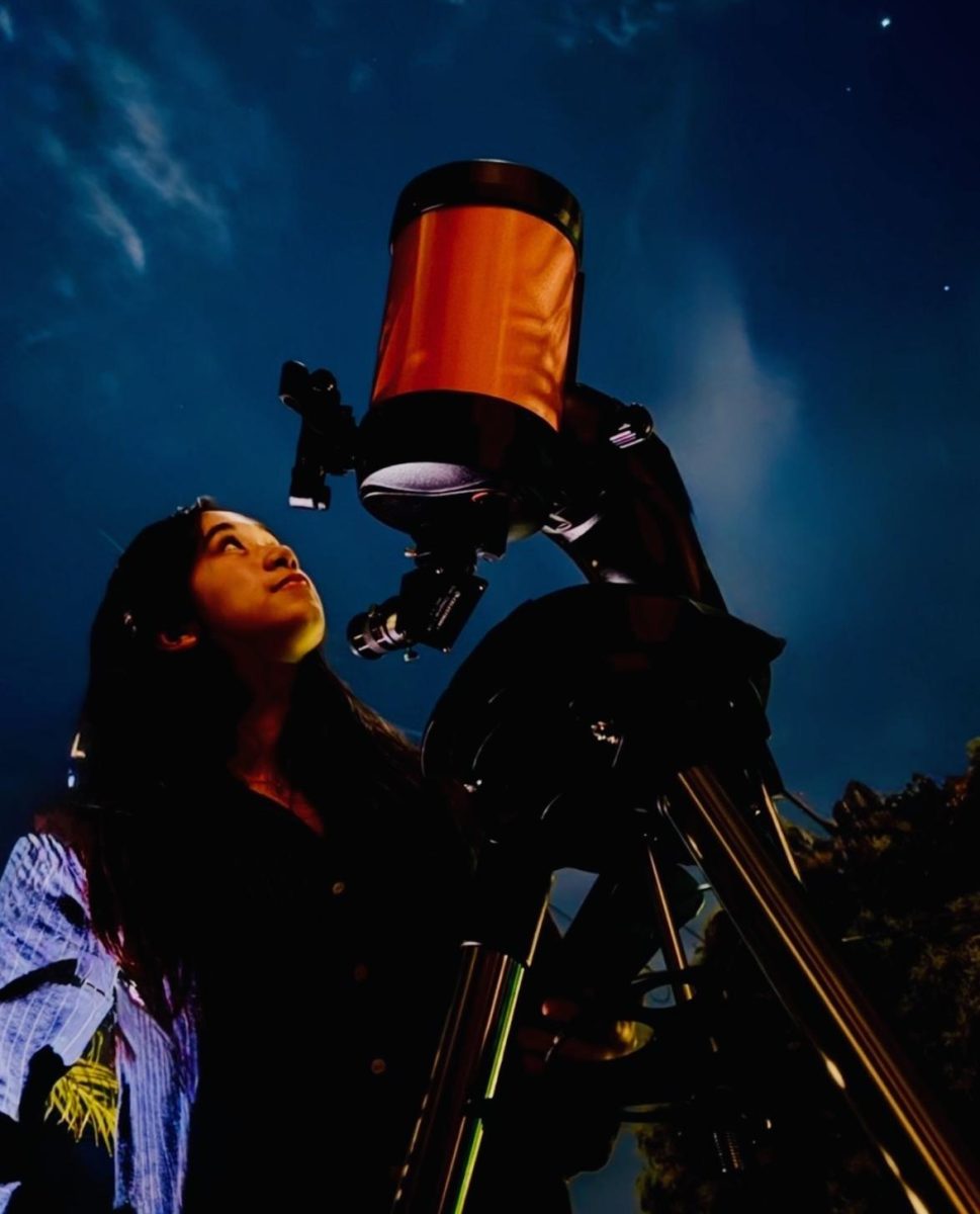 Bella Engleman gazing up at the sky through her telescope.                     Photo courtesy of Bella Engleman.